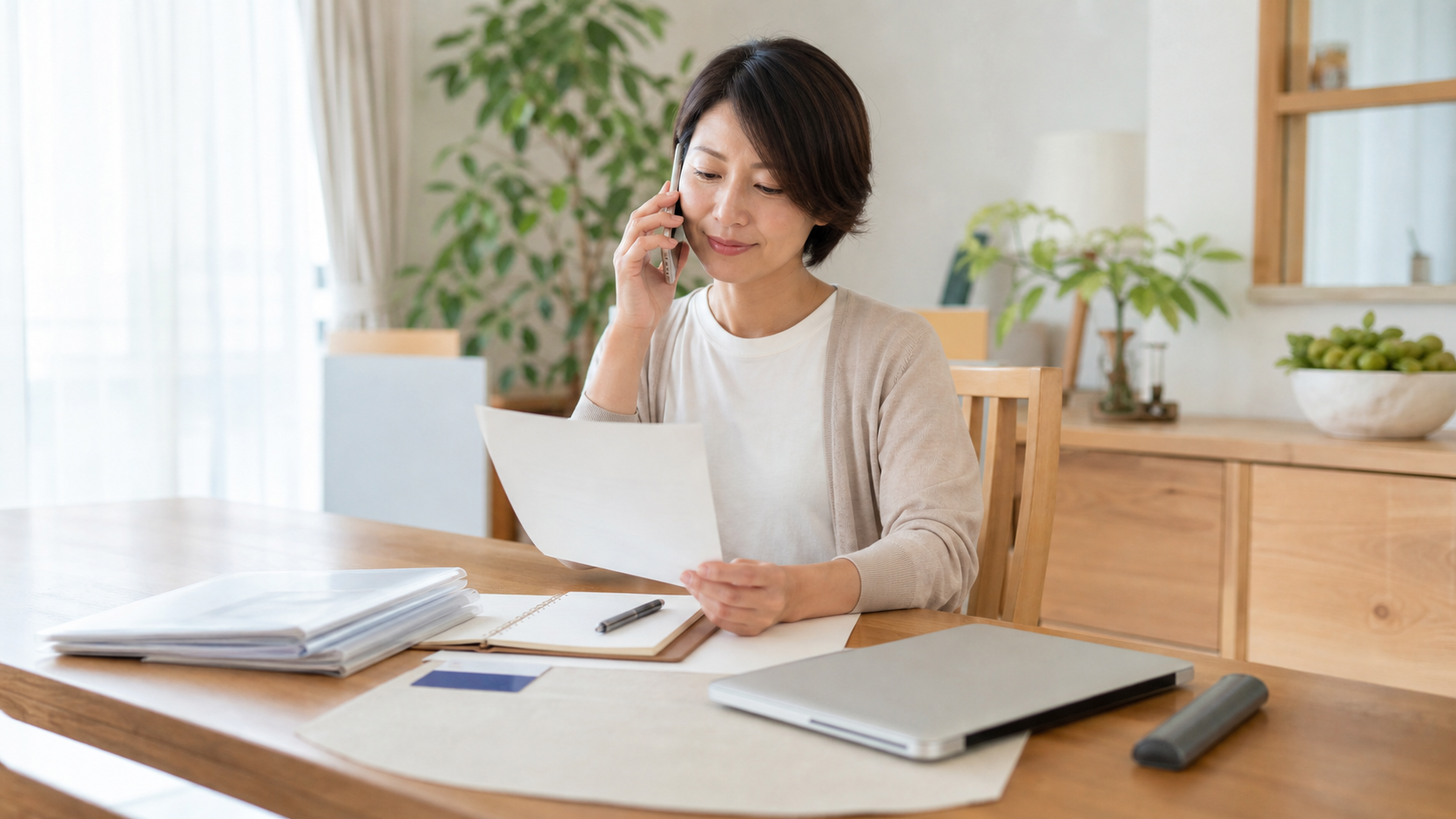家計書類を整理しながら専門の相談先へ電話する家族