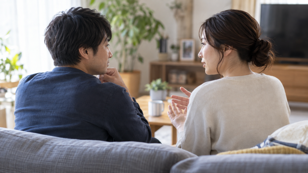リビングのソファで並んで話す二人の成人