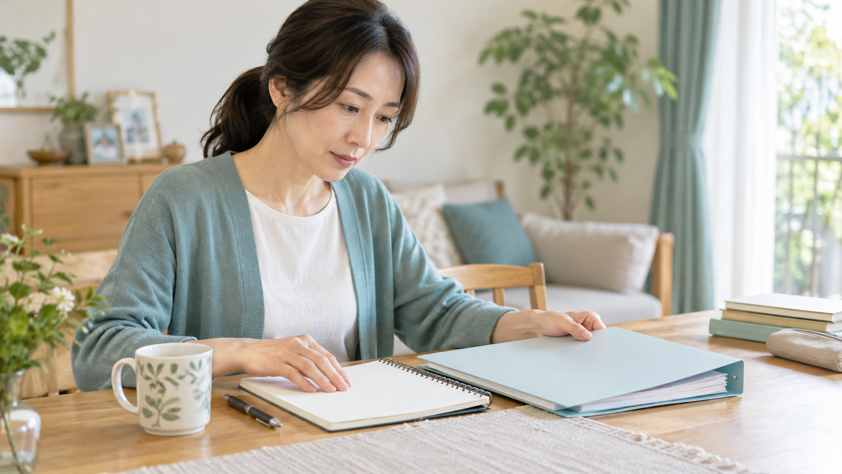 通院中の疑問を書いたノートと医療相談の資料を机に並べる成人